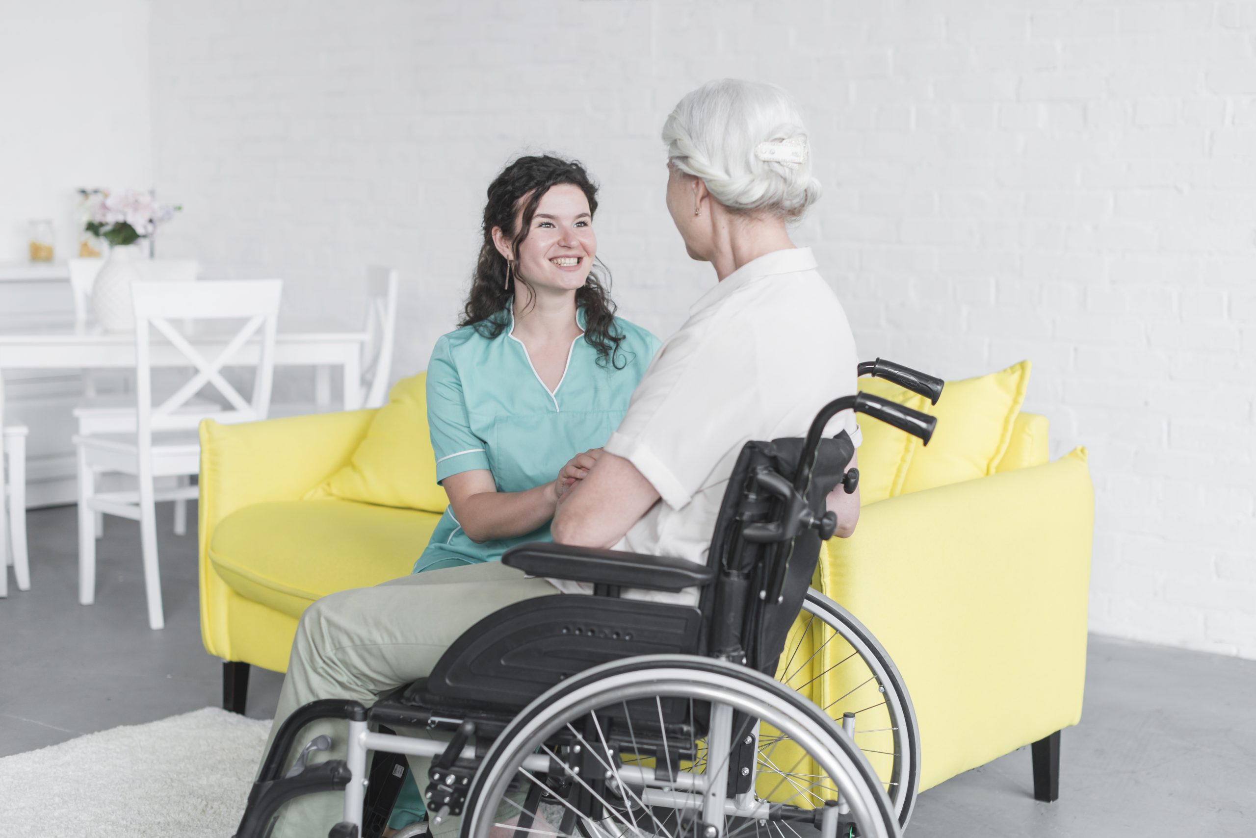 smiling-woman-looking-senior-woman-sitting-wheel-chair